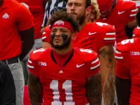 Brandon Inniss in a scarlet number 11 Ohio State jersey and headband on the sideline