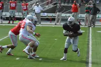 Ohio State quarterback Cardale Jones drops back to pass as defenders close in