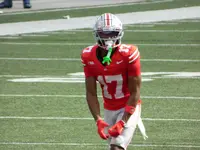Carnell Tate in a scarlet number 17 Ohio State jersey and silver helmet standing on the field