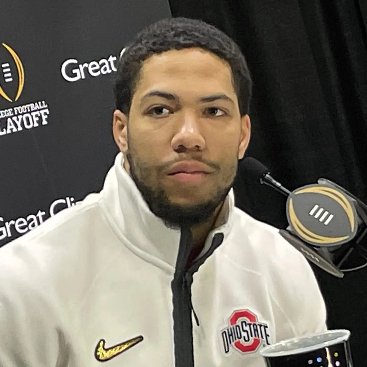 Cody Simon in a white Ohio State quarter-zip at a College Football Playoff media day podium