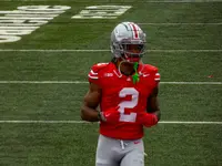Emeka Egbuka in a scarlet number 2 Ohio State jersey and silver helmet jogging on the field