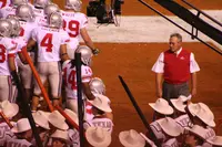 Ohio State coach Jim Tressel in a scarlet sweater vest watching his team before a game at Texas