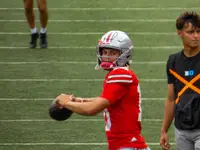Julian Sayin in an Ohio State uniform, holding a football in a throwing motion during pregame warmups