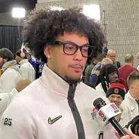 Lathan Ransom in a suit at a podium during College Football Playoff media day