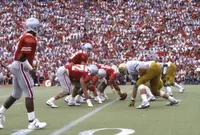 One Ohio State player in scarlet standing alone wide to the left while the rest of the offense lines up against Colorado in a full Ohio Stadium