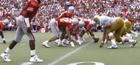 Ohio State players in scarlet at the line of scrimmage against Colorado players in gold and white at Ohio Stadium