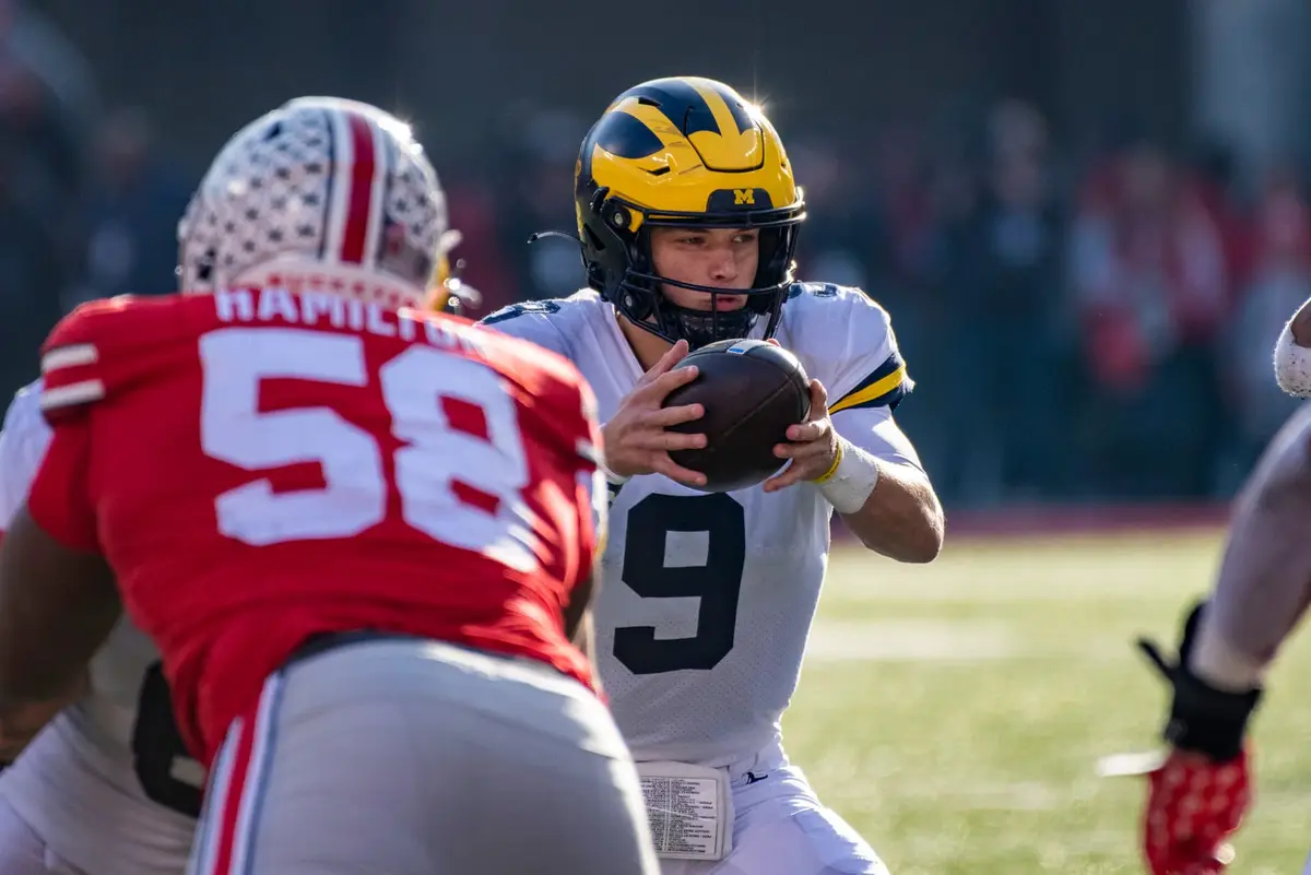 Ohio State defensive tackle Ty Hamilton, number 58 in scarlet, lined up across from the Michigan quarterback as he takes the snap
